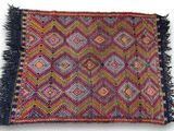 a multicolored rug with fringes on a white background