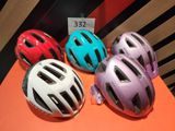 several helmets are lined up on an orange surface with a price tag