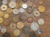 a pile of coins on a table with a pair of scissors next to it