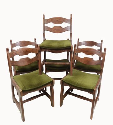 four wooden chairs with green cushions sit in a row