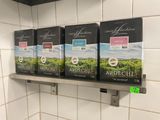 trois boîtes de thé posées sur une étagère dans une cuisine