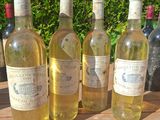 several bottles of wine are lined up on a wooden table