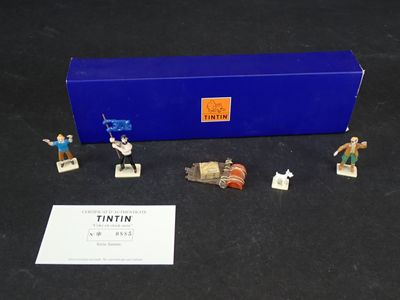 figurines de Tintin dans une boîte bleue posée sur une surface noire