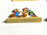 three pin badges of cartoon characters on a white surface