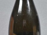 a black bottle with a yellow top on a gray surface