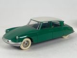 a green toy car with white wheels on a white surface