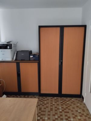a room with a desk, cabinets, and a printer