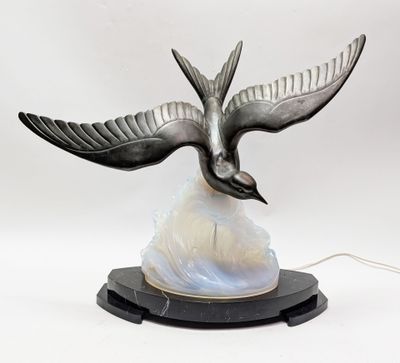 une sculpture représentant un oiseau en plein vol au-dessus d'un rocher