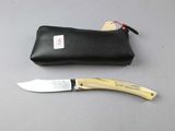 a knife that is laying next to a pouch