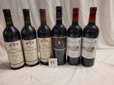 several bottles of wine are lined up on a table