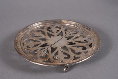 a silver plate with a design on it on a table