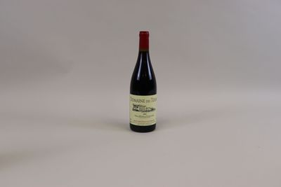 une bouteille de vin rouge posée sur une table blanche