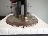 a statue of a man with a guitar on top of a bed