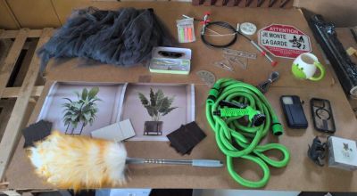 un chat allongé sur une table sur laquelle se trouvent divers objets