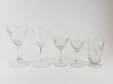 four wine glasses are lined up in a row on a white surface