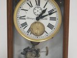 une horloge avec des chiffres romains dans un boîtier en bois