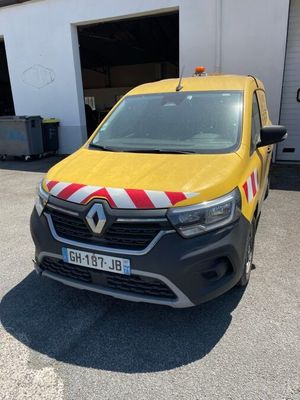 a yellow van parked in front of a building with a red and white stripe on it