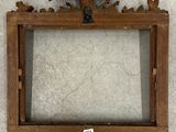 an old wooden picture frame with a bird on top of it
