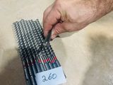 a man that is holding a bunch of drill bits in his hand