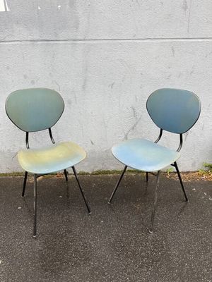 two chairs sitting next to each other on the pavement