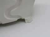 a white vase sitting on a table with a white background