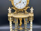 une horloge dorée et blanche posée sur une table