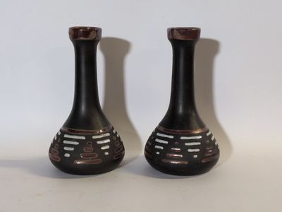 deux vases noirs posés l'un à côté de l'autre sur une table