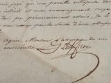 un très vieux document portant des inscriptions, posé sur une table