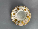 yellow and white cup and saucer sitting on top of a table