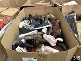 many pairs of shoes in a cardboard box on the floor