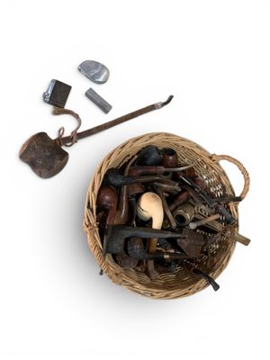 un panier rempli d'outils de toutes sortes posé sur une surface blanche