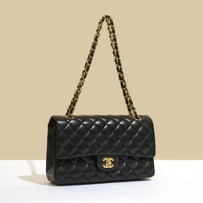 un sac Chanel noir posé sur une surface blanche