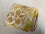 a yellow and white flower on a yellow and white napkin