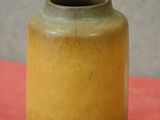 un vase jaune et bleu posé sur une table rouge