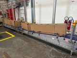 un tapis roulant sur lequel sont posées des caisses, dans un entrepôt