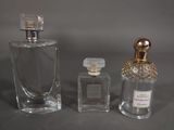 two bottles of perfume sitting next to each other on a table