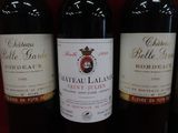 plusieurs bouteilles de vin sont alignées sur une étagère