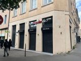 des personnes marchant sur le trottoir devant un immeuble