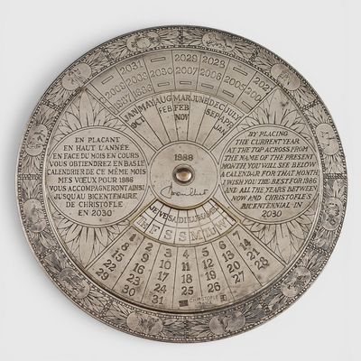 une assiette en argent ornée d'un cadran solaire, posée sur un fond blanc