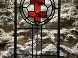 a stained glass window with a red cross on it