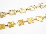 three pieces of gold bracelets on a white surface