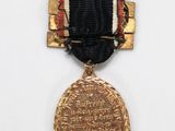 an image of a gold medal with a black ribbon around it
