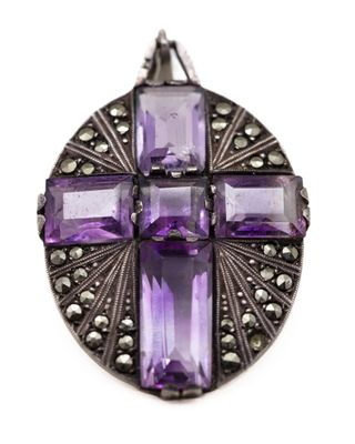 un gros plan d'un pendentif en forme de croix en pierre violette sur fond blanc
