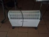 a white heater sitting on a tiled floor next to a table