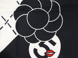 a close up of a black and white shirt with a flower on it