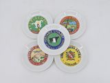 four white plates with different types of badges on them on a white surface
