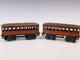 une paire de wagons de train miniature posés sur une surface blanche, avec un fond blanc