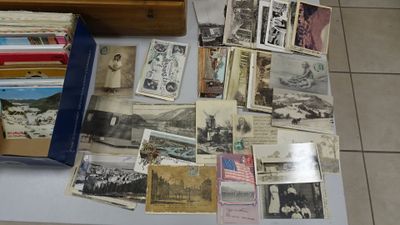 a lot of old photos and postcards on a table