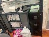 a desk with a printer, file cabinet, and other office supplies