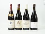quatre bouteilles de vin sont alignées sur une surface blanche
